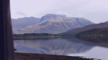 The view out the window of the Jacobite Steam Train as it crosses a lake in the Highlands