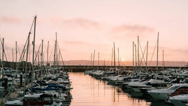 Boats moored in St. Helier Marina at sunset.