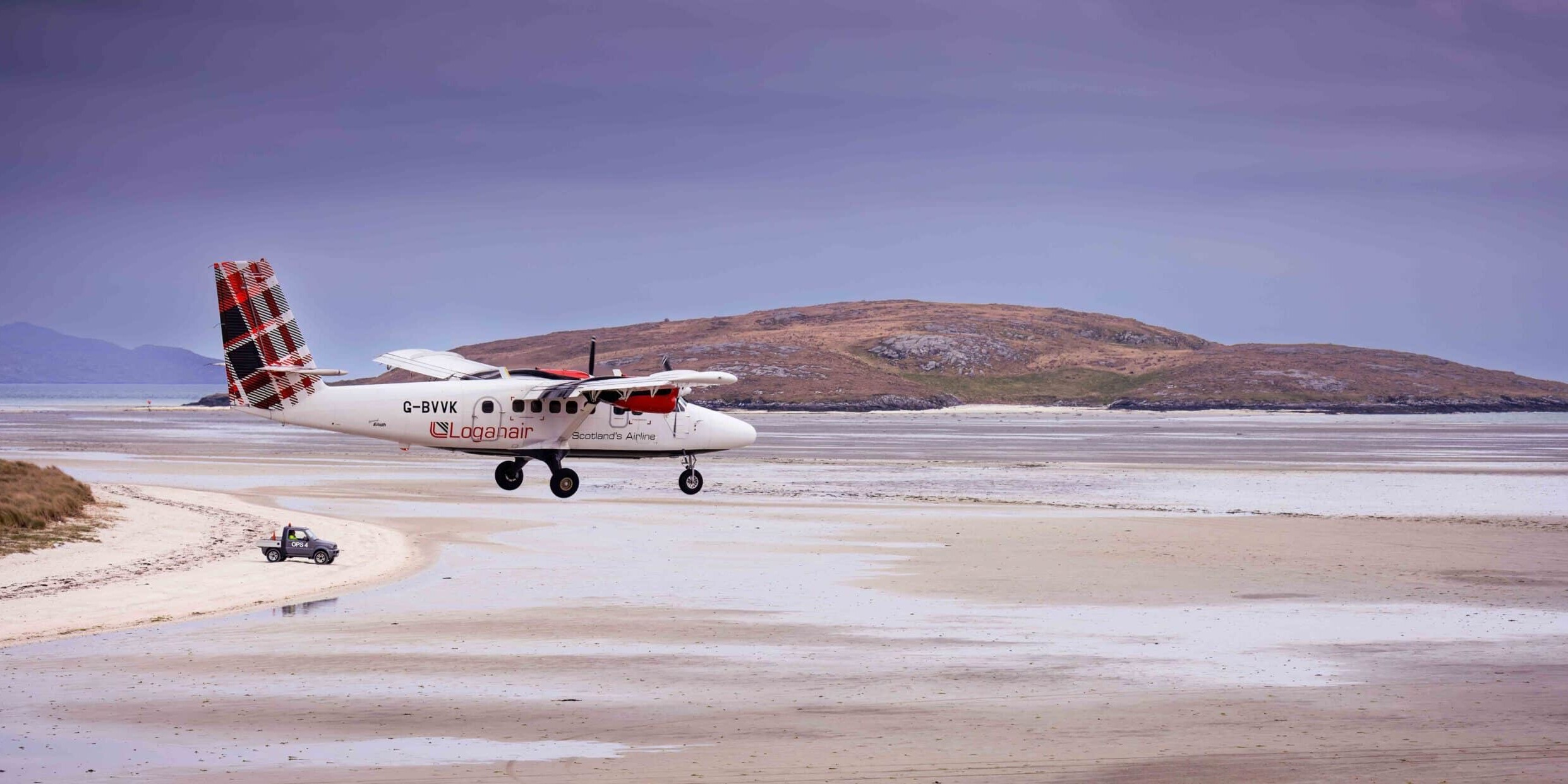 A Loganair flight landing on Barra Airport.